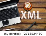 Small photo of Extensible Markup Language. Word XML on wooden desk with laptop