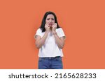 Small photo of terrified woman giving fearful expression. Indian girl in fear looking away. Scared timid and insecure woman , screaming and looking terrified, shivering from fear, orange background
