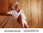 Elderly woman sitting relaxed in a wooden sauna