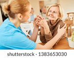 Small photo of Demented or ill senior woman is being comforted by a geriatric nurse in the nursing home