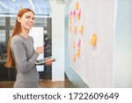 Smiling business woman or trainee in brainstorming workshop with sticky notes