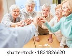 Small photo of Group of demented seniors trains their memory while playing puzzles in a nursing home