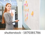 Young business woman as a trainee or student brainstorming with sticky notes