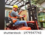 Small photo of Waving forklift driver in the warehouse of a haulage company while driving forklift