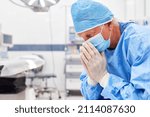 Small photo of Exhausted and worried surgeon sits in the operating room after a strenuous operation