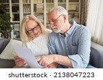 Small photo of Senior couple reading a retirement plan or power of attorney or living will