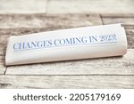 Small photo of Changes coming in 2023 is written on the front page of a folded newspaper on a wooden table