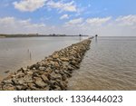 Small photo of Dams made of stone together, sea waves make the land disappear.