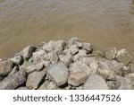Small photo of Dams made of stone together, sea waves make the land disappear.