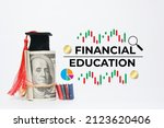 Small photo of A picture of financial education and knowledge concept. Mortarboard, fake money, miniature book, stochastic, pie chart, coin and magnifying glass illustration with the word financial education.