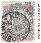 Small photo of RHODESIA - 1896: An ½ pence slate and violet postage stamp depicting Arms of the British South Africa Company. The ends of ribbons containing motto cross the animals legs
