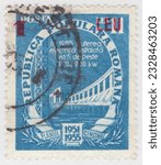 Small photo of ROMANIA - 1952: An 1 on 11 lei blue postage stamp depicting Hydroelectric Production. River on the lower biff of a hydroelectric dam with an engine room and lattice transmission tower. Five Year Plan