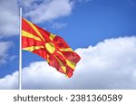 Small photo of The Macedonian Flag - It portrays a yellow sun with rays on a red background. The eight rays extend from the middle towards the margin as they broaden, representing “the new sun of liberty.”