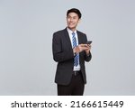 Handsome and friendly face asian businessman smile in formal suit his using smartphone on white background studio shot.