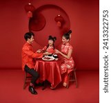 Small photo of Asian family holding angpao gift in the meal on celebration chinese new year 2024 isolated on red backdrop. Chinese text means Have a wish Blessing 5, good luck and much happiness, rich