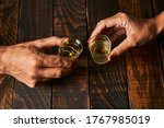 Hands with shot glasses toasting. Concept of alcoholism and addiction.