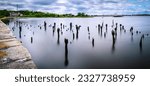 Ruined pilings and water reflections at the harbor in Seekonk River, Providence, Rhode Island, long exposure photography
