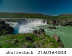Long exposure photo of magnificent Godafoss waterfall in northern Iceland on a warm summer day. Visible frog from drops of water coming from the waterfall.