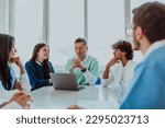 Small photo of A group of multiethnic medical professionals including doctors, surgeons, and nurses are gathered in a hospital setting discussing patient care and using modern technology to address challenges in