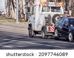 Small photo of Tow truck carrying improperly parked car or repossessed vehicle.