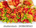 Small photo of Colorful chili peppers. Bunch of colorful chili peppers at the Rialto Bridge market in Venice. Sheaf of colorful chilli peppers. Concept of fresh organic food market. Chilli for sale in market.