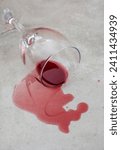 Small photo of Empty glass with spilt wine on grey