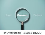 Present wording inside of Magnifier glass on blue background for focus current situation , positive thinking mindset concept.