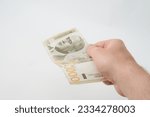 Small photo of Unknown caucasian man holding 2000 Serbian Dinar RSD banknote money isolated on white background