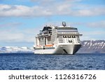 white cruise liner against the background of mountains and fjords in the North sea