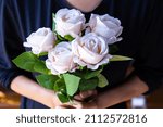 Woman holding white rose in hand. Valentine's day concept, marriage, gift, congratulation, happiness. spot focus.