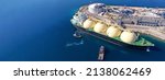 Small photo of Aerial drone ultra wide panoramic photo with copy space of LNG (Liquified Natural Gas) tanker anchored in small gas terminal island with tanks for storage