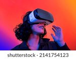 Small photo of The young woman is using virtual reality viewer. Modern woman portrait with trendy look and bright colors.