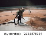 Small photo of Male worker surface corrosion plate preparation by sandblasting bounce off of tank top deck pontoon.