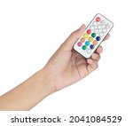 Hand holding remote with colored buttons for LED light lighting and decoration isolated on white background