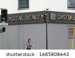 Small photo of San Francisco, CA - Mar 1, 2020: A woman walks past the Digital Realty Data Center in downtown SF. Digital Realty Trust invests in carrier-neutral data centers with colocation and peering services.