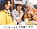 Small photo of Group of senior women at bar cafeteria enjoying breakfast drinking coffee and eating croissant - Life style concept - Mature female having fun at bistro cafe and sharing time together