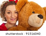 Close up of woman face holding big teddy bear against white background