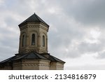 A fragment of the tower of a stone old Orthodox church against a cloudy sky. Bottom view. High quality photo
