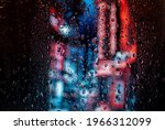 Raindrop on the window, backgorund is bluried a light of city. City life in night in rainy season abstract background.