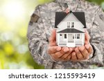 Soldier Holding A Model Of House