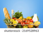 Shopping cart full of fresh groceries, grocery shopping concept on background