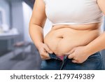Small photo of Cropped of overweight fat woman holding tummy flabs with obesity. Inclination body. Adipose stomach. Big size.