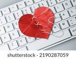 Small photo of Red heart paper on keyboard computer background. Online internet romance scam or swindler in website application dating concept. Love is bait or victim.