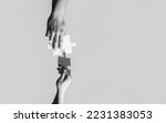 Small photo of Closeup hands of man connecting jigsaw puzzle. Business solutions, success and strategy concept. Black and white. Two hands trying to connect couple puzzle with yellow background.