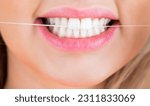 Small photo of Dental floss. Taking care of teeth. Teeths Flossing. Dental flush - woman flossing teeth. Oral hygiene and health care. Smiling women use dental floss white healthy teeth.