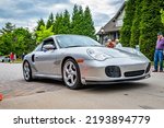 Small photo of Highlands, NC - June 10, 2022: Low perspective front corner view of a 2002 Porsche 911 Turbo Tiptronic Coupe leaving a local car show.