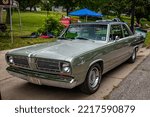 Small photo of Des Moines, IA - July 01, 2022: High perspective front corner view of a 1968 Plymouth Valiant Signet 2 Door Sedan at a local car show.