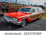 Small photo of Iola, WI - July 07, 2022: High perspective front corner view of a 1963 Ford Country Squire Station Wagon at a local car show.