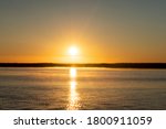 Sunset sky background. Gold sunset sky with evening sky clouds over the lake with fog.Crystal clear water texture. Small waves with water reflection