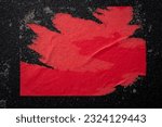 A piece of red paper on a black wall.